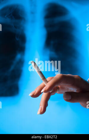 woman smoking a cigarette, .X-ray photograph of a lungs in the background Stock Photo