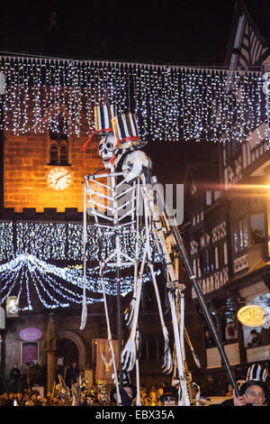 Chester, UK 4th December, 2014. Mid-Winter Watch Parade from Town Hall Square, down St. Werburgh Street, Eastgate Street, Bridge Street, The Cross and Northgate Street.  Karamba Samba a ‘ghost band’ led a fun parade of skeletons, fire breathing, skeleton Christmas cooks, angels and devils as they celebrated the Winter solstice. An event which dates from the 1400’s, where local artists and community groups join together to celebrate the time when the city leaders would hand over the keys to the city. Stock Photo