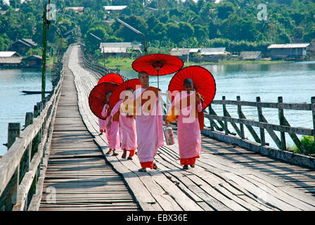 a group of nuns and convent pupils with sunshades on a wooden bridge, Thailand, Sanglaburi Stock Photo
