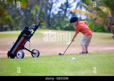 4 years old boy playing golf on a golf course Stock Photo