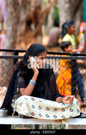 young Indian woman with cellular phone in Children's Park, India, Chennai, Madras Stock Photo