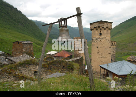 Ushguli, bell in a mediaeval village with typical Svanetian protective towers, Georgia, Caucasus Stock Photo