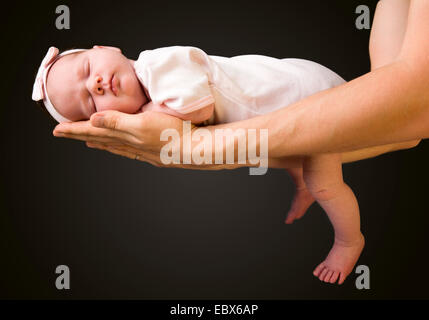 Supporting Hands. Father holding his 14 days old baby girl on his arms Stock Photo