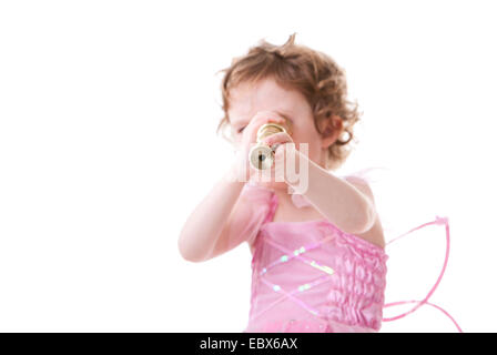 Cute curly haired girl in little fairy dress looking to telescope Stock Photo