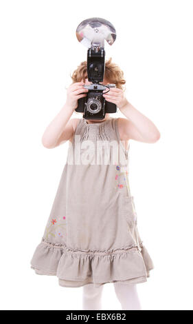 Young Photographer. Little girl playing with antique camera. Stock Photo