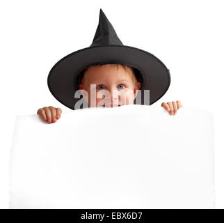 playful boy in witch hat holds white banner. Stock Photo