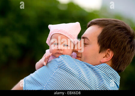 Happy young father and his baby daughter outdoors at sunny day Stock Photo