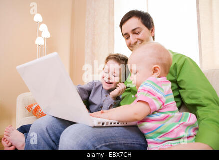 Young father and two kids with laptop Stock Photo