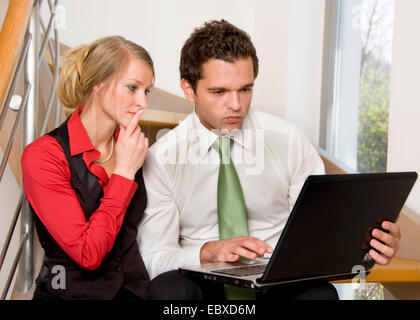 Two young businesspeople using laptop Stock Photo