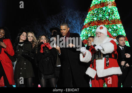 US President Barack Obama joins Santa Claus and entertainers in a dance during the lighting of the national Christmas tree on the Ellipse December 4, 2014 in Washington, DC. Obama urged Americans to remember members of the U.S. military serving overseas, as well as their families. This year's ceremony marks the 92nd annual lighting of the Christmas tree near the White House. The White House tree lighting is a tradition dating to 1923. Stock Photo