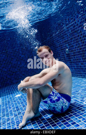 underwater shot of a man sitting in a swimming pool Stock Photo