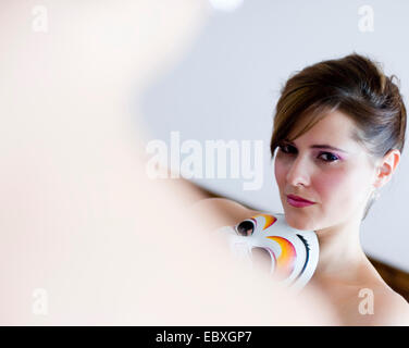 young woman looking at mirror Stock Photo