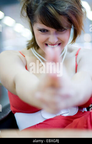 attractive brunette woman in a red aiming at the camera Stock Photo
