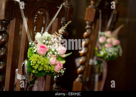 Flower bouquets hanging on the chairs for the wedding couple. Stock Photo