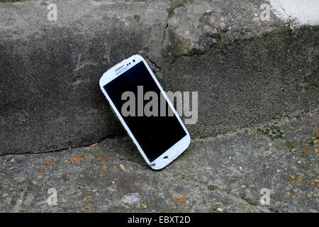 dropped smart phone with smashed case and screen at bottom of steps Stock Photo
