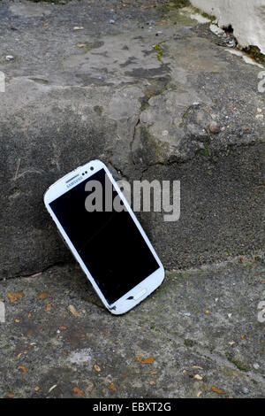 dropped smart phone with smashed case and screen at bottom of steps Stock Photo