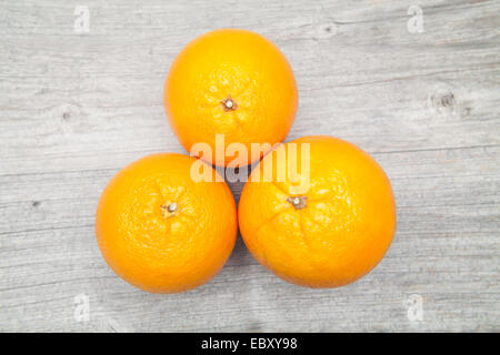 three oranges top view on grey table Stock Photo