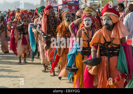 Group of Gudar Sadhus, holy men, walking in a row and collecting offered food from fellow sadhus, at the Sangam, the confluence Stock Photo