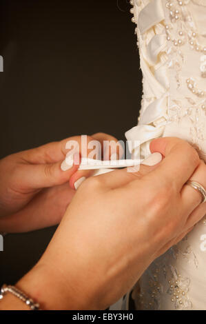 Wedding dress corset being tied from behind. Stock Photo
