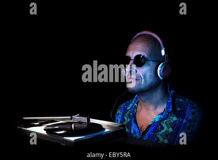 Caucasian man with headphones and sunglasses hearing music from an old turntable Stock Photo
