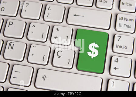 Spanish keyboard with finance money cash icon over green background button. Image with clipping path for easy change the key col Stock Photo