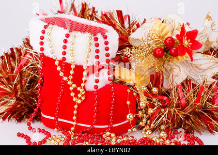 Christmas decoration with Santa's red boot, garland, beads closeup picture. Stock Photo