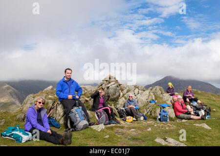 Group of local Ramblers taking a lunch break on Yr Aran summit in mountains of Snowdonia National Park, Gwynedd, North Wales, UK