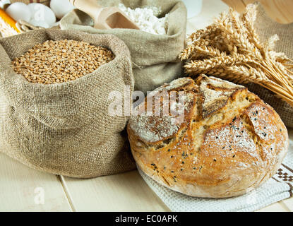 Homemade bread and wheat grain on table