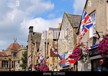 Row of British flags on shop walls in the town centre, Bakewell, Derbyshire, England, UK, Western Europe. Stock Photo