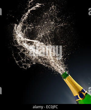 Bottle of champagne with splash isolated on black background Stock Photo