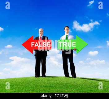 Two Businessmen Holding Contrasting Arrows for False and True Stock Photo