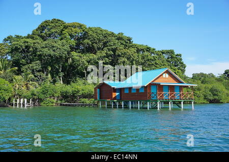 Overwater bungalow with lush tropical vegetation in background, Caribbean, Bocas del Toro, Panama Stock Photo