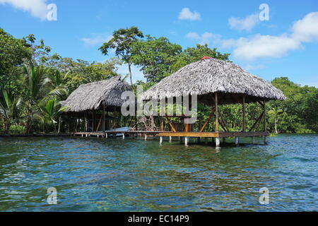 Waterfront property with thatched tropical hut and boathouse over the sea, Caribbean, Panama Stock Photo