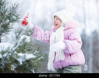 Happy kid making christmas tree decorations outdoor Stock Photo
