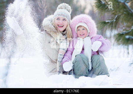 Happy parent and kid playing with snow in winter outdoor Stock Photo