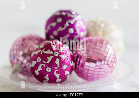 Pink and purple Christmas decorations on a glass plate Stock Photo