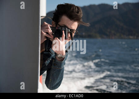Young male photographer at sea. Stock Photo