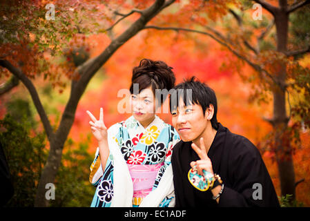 Young Japanese couple in traditional costume, enjoying the autumn color in Kyoto, Japan. Stock Photo