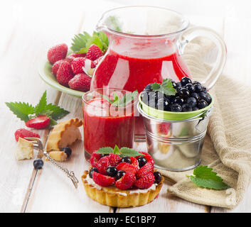 Strawberry smoothie with sweet cake and fresh berries on a wooden table . Selective focus Stock Photo