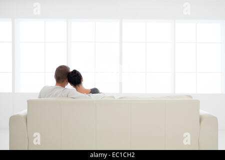 back view of young couple in love relaxing on sofa Stock Photo
