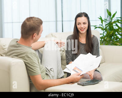 couple doing their accounts at home and laughing Stock Photo