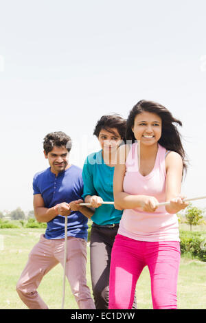 indian friends group park playing Tug of War Stock Photo