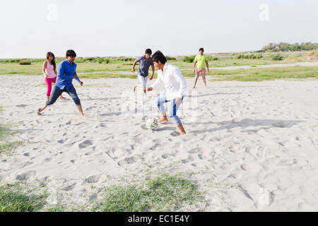 indian friends group Playing Football Stock Photo