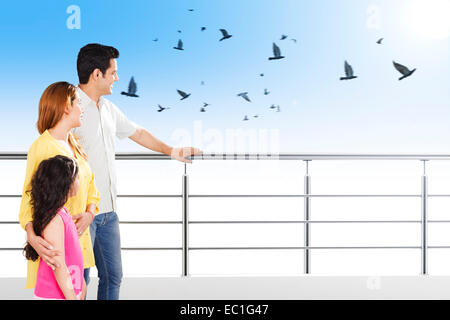 indian Parents with child Balcony side  showing bird Stock Photo