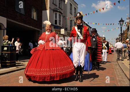 Dickens Festival grand parade, Rochester, Kent. Lady in red dress with officer, Rochester High Street. Novelist Charles Dickens lived nearby in Chatham as a boy, and in Gad’s Hill Place, Higham, , Rochester from 1857-1870. Stock Photo