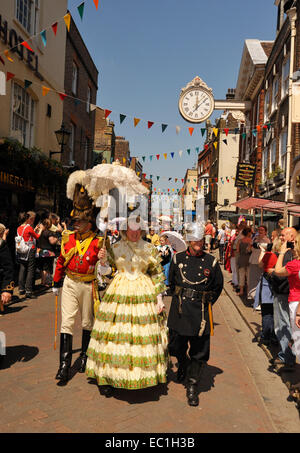 Dickens Festival grand parade, Rochester, Kent. Lady in red dress with officer, on Rochester high Street beneath famous Stock Photo