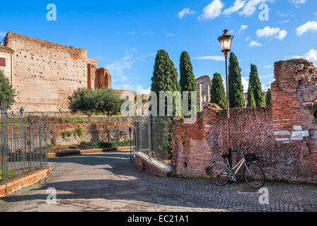 City bicycle stand leaning on old brick wall and lamppost on narrow street in Rome, Italy. Stock Photo