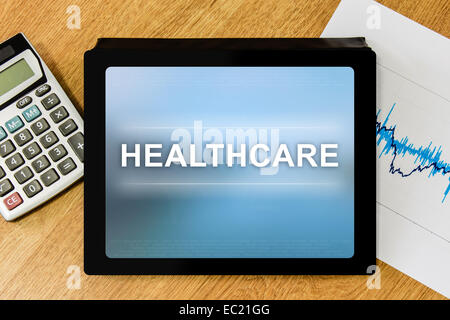 healthcare word on tablet with calculator and financial graph Stock Photo