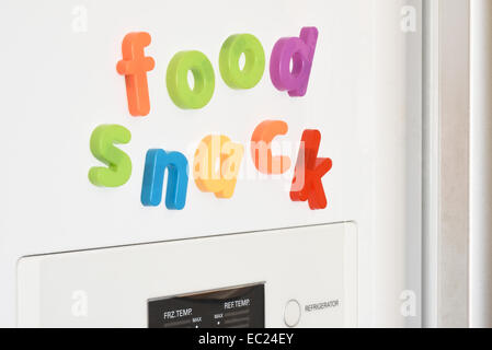 The words 'Food & Snack' spelled out in fridge magnets on the door of a fridge. Stock Photo