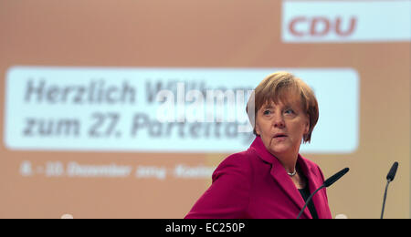 Cologne, Germany. 08th Dec, 2014. Chancellor Angela Merkel inspects the hall under the words 'Welcome to the 27th party convention' before the CDU federal party convention in Cologne, Germany, 08 December 2014. The party convention takes place on Tuesday and Wednesday. Photo: OLIVER BERG/dpa/Alamy Live News Stock Photo